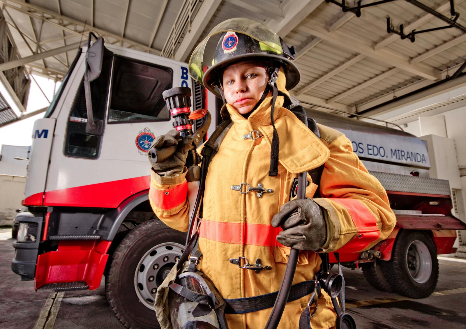 Female firefighter beside fire truck